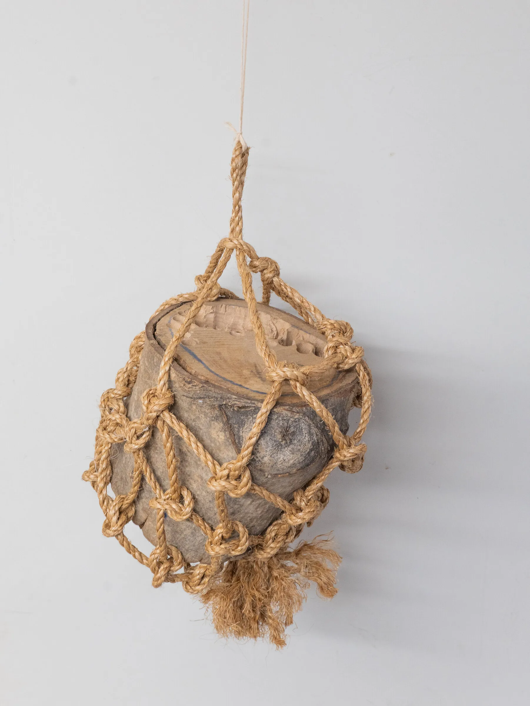 The cradle carrying a section of log, suspended from a single rope.