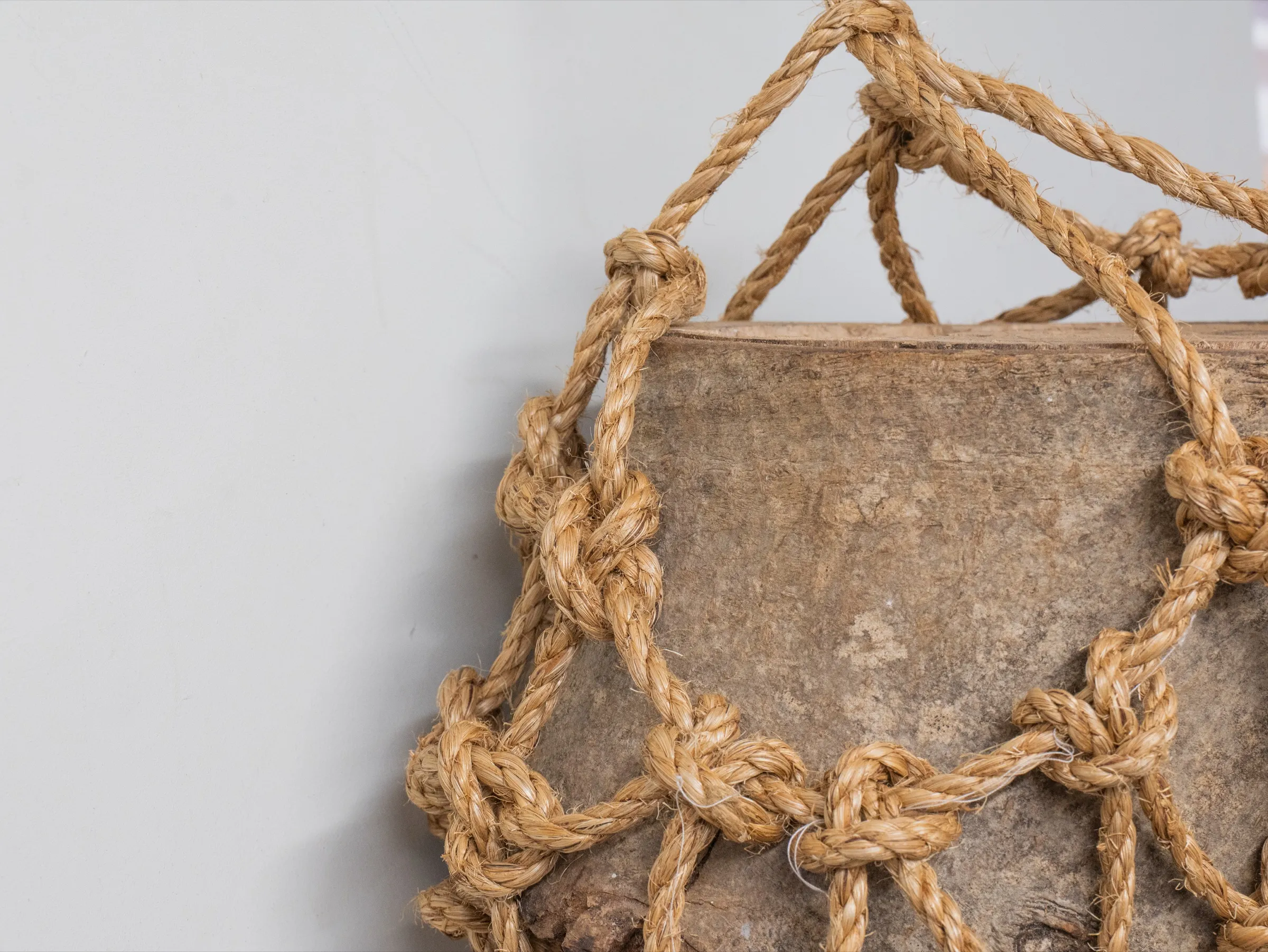 The manilla rope cradle opened around a piece of timber.